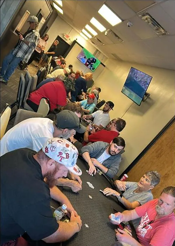 A full table at River Cities Royale mid-hand, with the rest of the room behind it